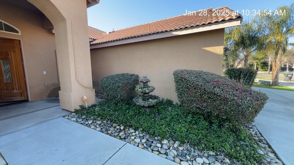 A house with a brown door and a small garden in front.