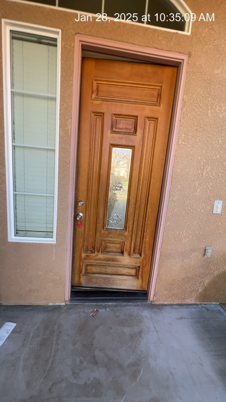 A brown door with a glass panel is closed.