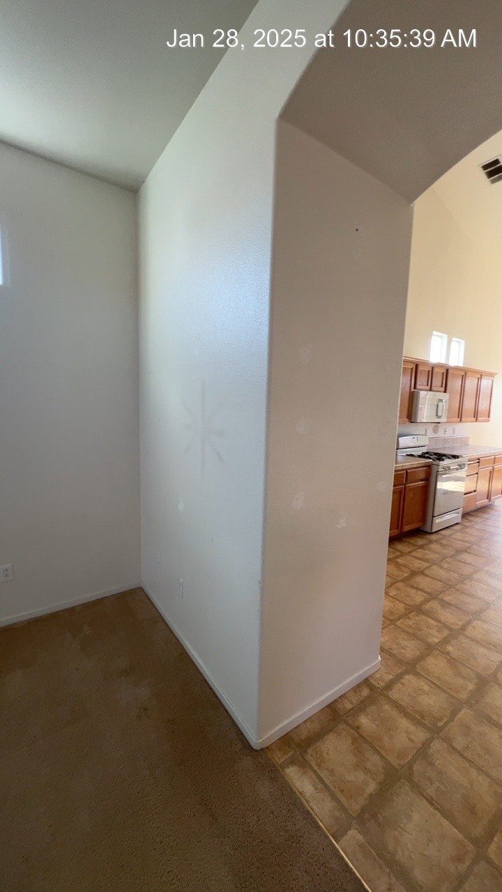 A white wall in a room with a tiled floor.