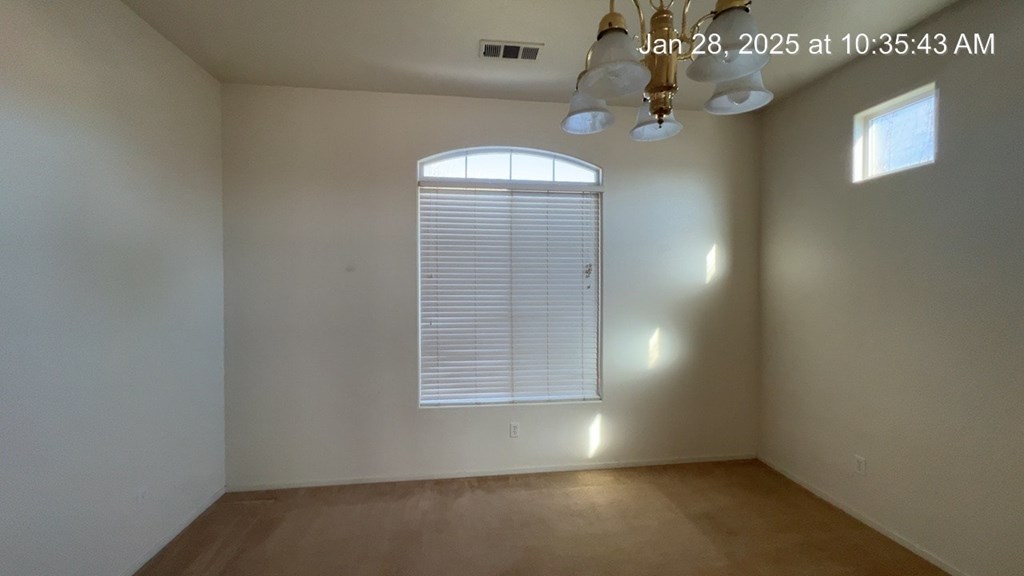 A room with a window and a chandelier.