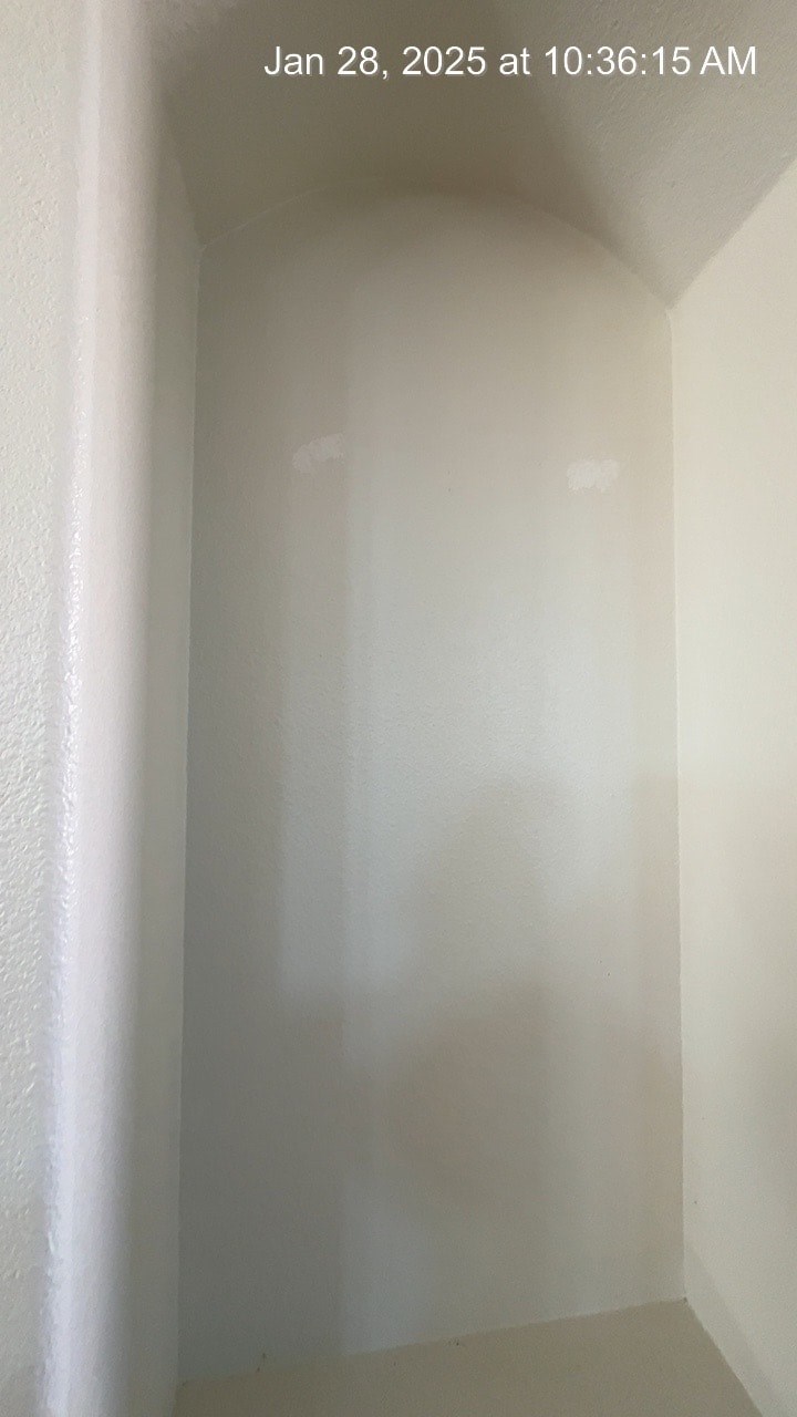 A white hallway with a light source coming from the top.