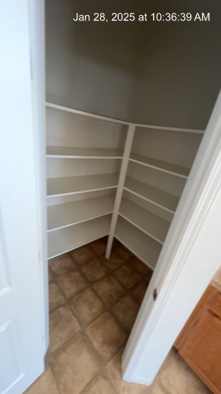 A white door is open to a hallway with a tiled floor.