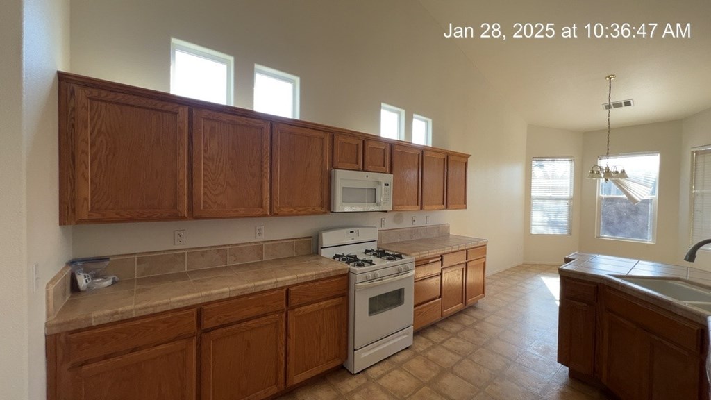 A kitchen with wooden cabinets and a white stove top oven.