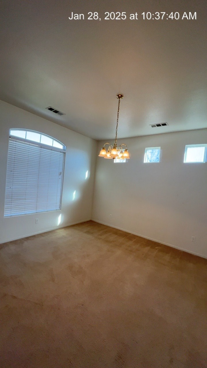 A room with a chandelier and windows.