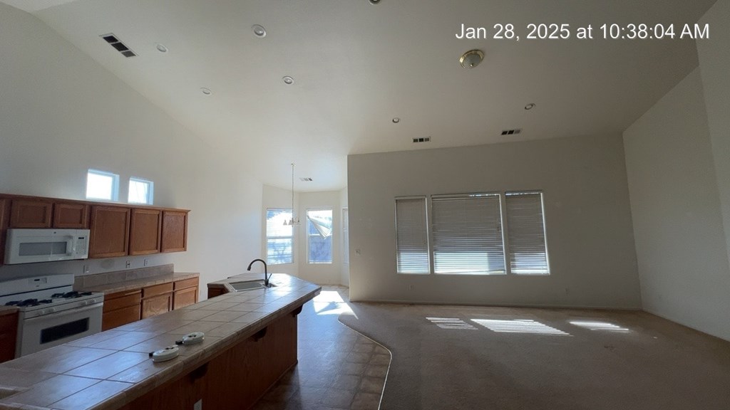 A kitchen with wooden cabinets and a countertop is empty and ready for renovation.