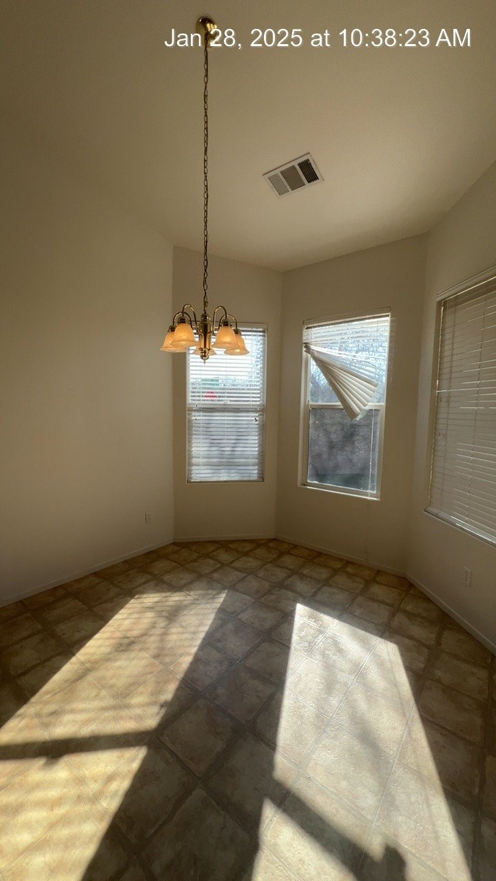 A sunny room with a tiled floor and a window with blinds.