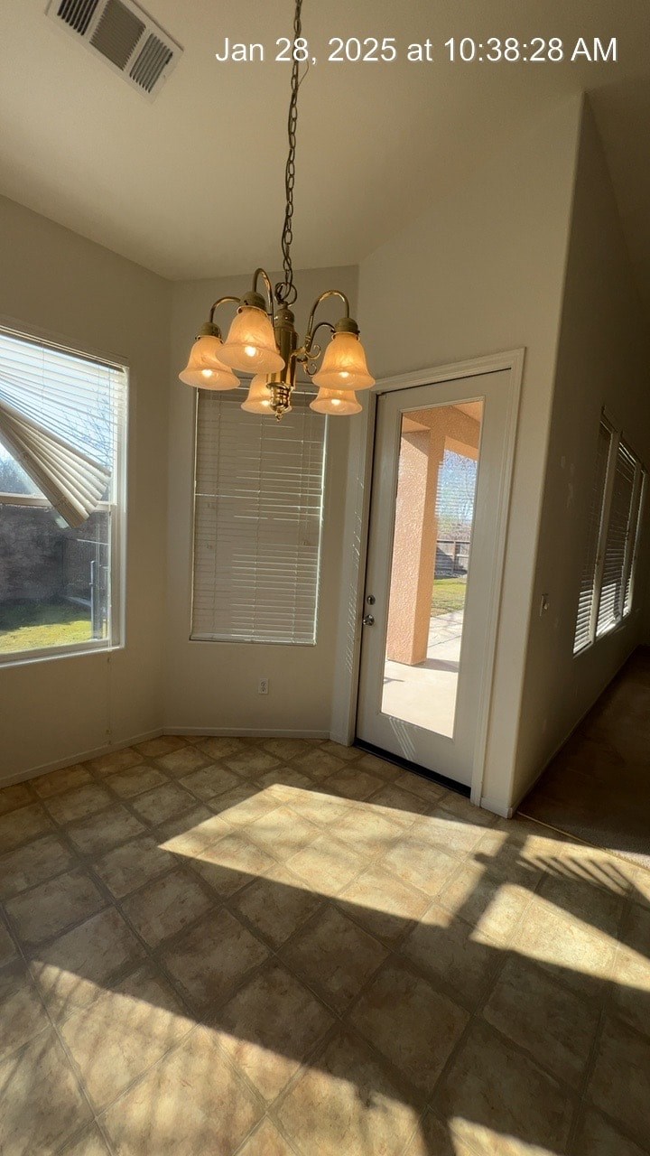 A room with a tiled floor and a chandelier hanging from the ceiling.