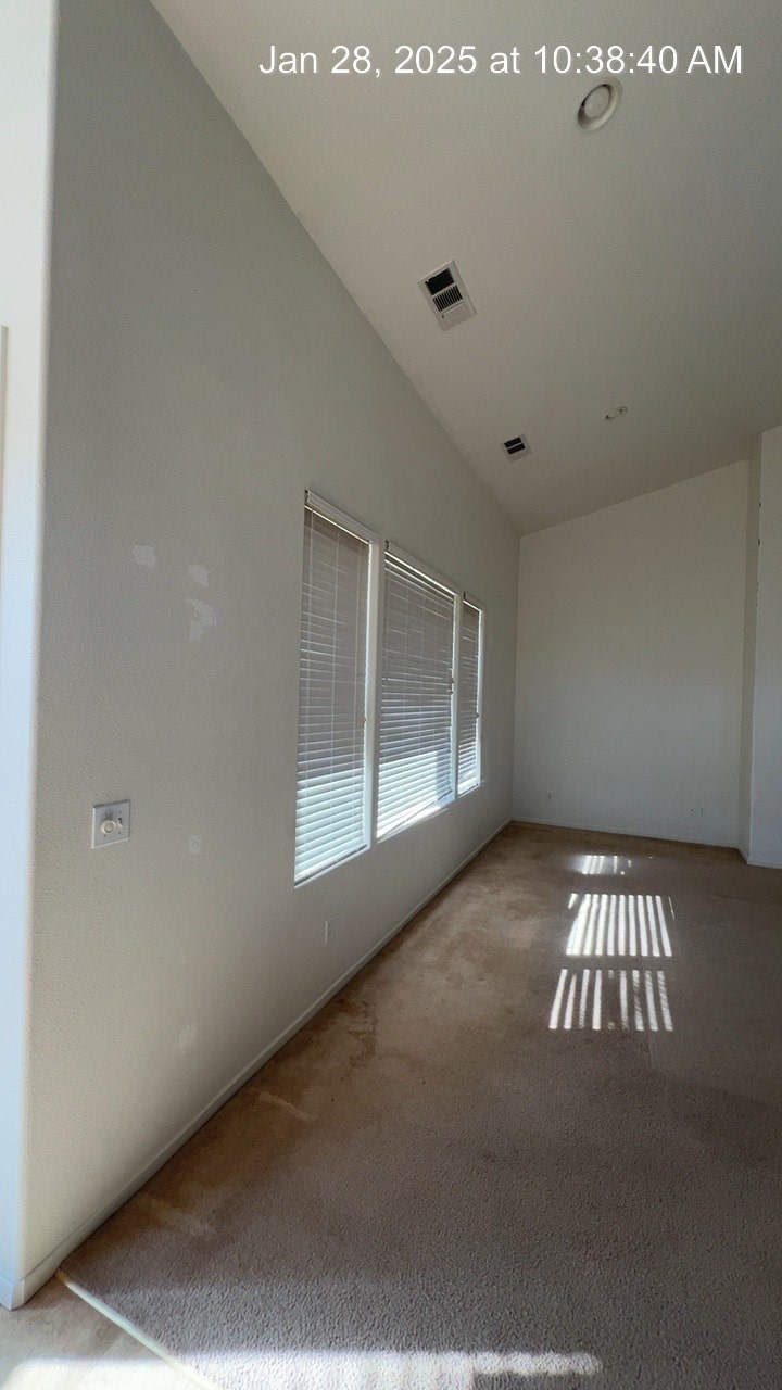 A room with a window and a striped rug on the floor.
