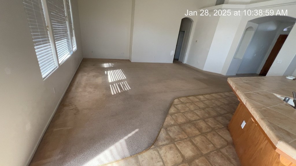A room with a brown floor and a wooden cabinet.