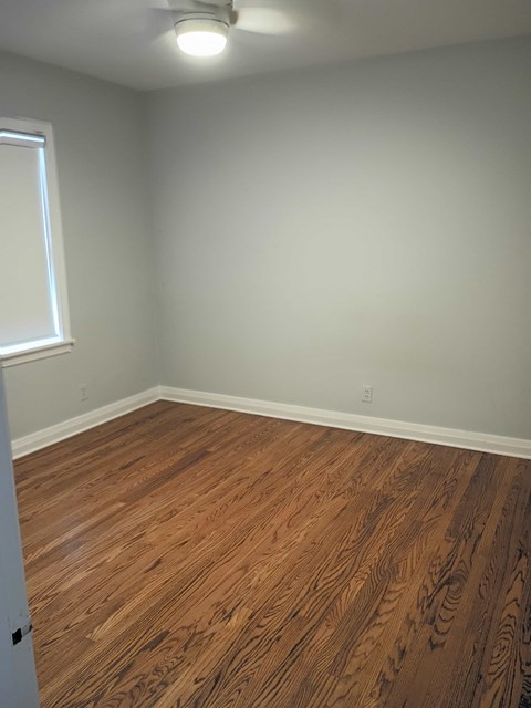 A room with wooden flooring and a window.