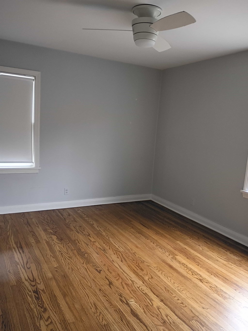 A room with a ceiling fan and a window.
