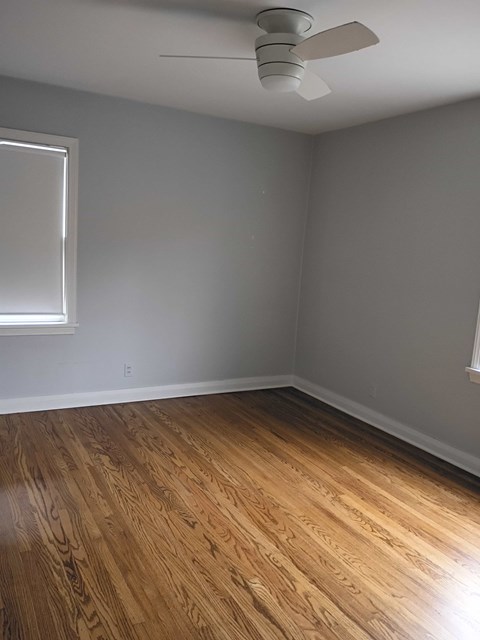A room with a ceiling fan and a window.