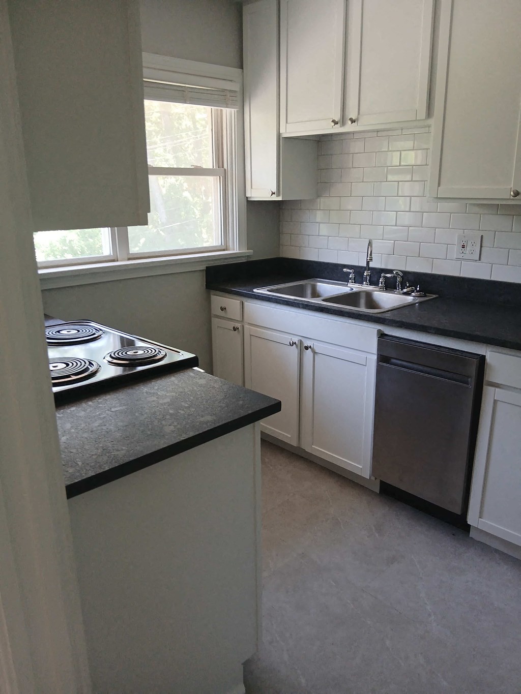a kitchen with white cabinets and a stove and sink