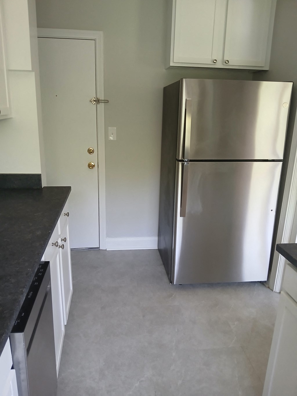 a kitchen with a stainless steel refrigerator and white cabinets