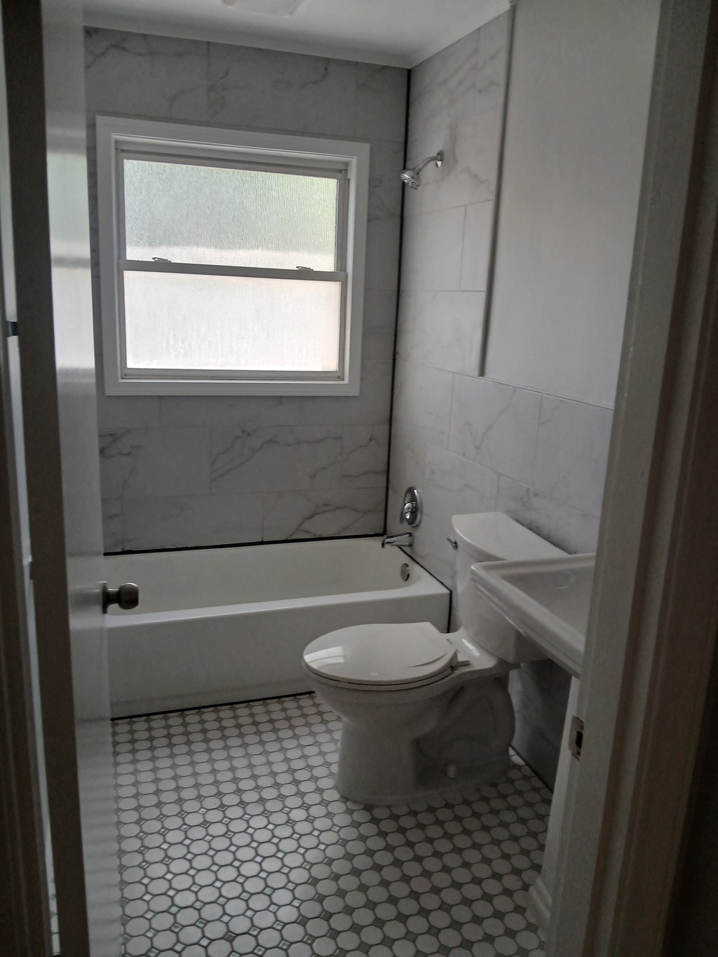 a bathroom with a toilet and a tub and a window