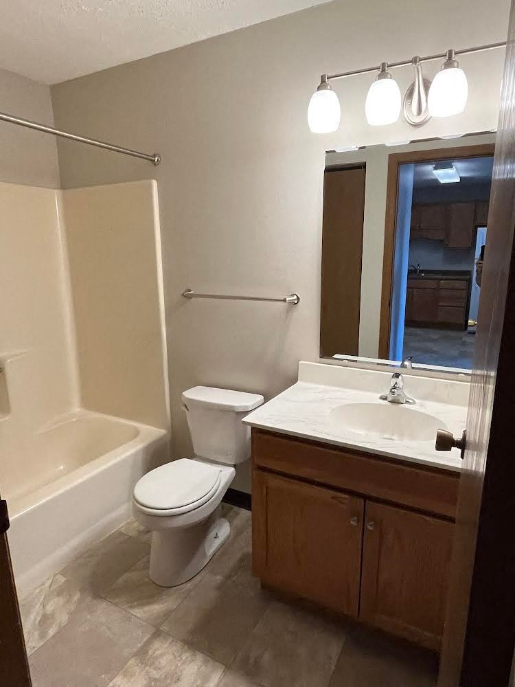 A white toilet sits next to a sink in a bathroom.