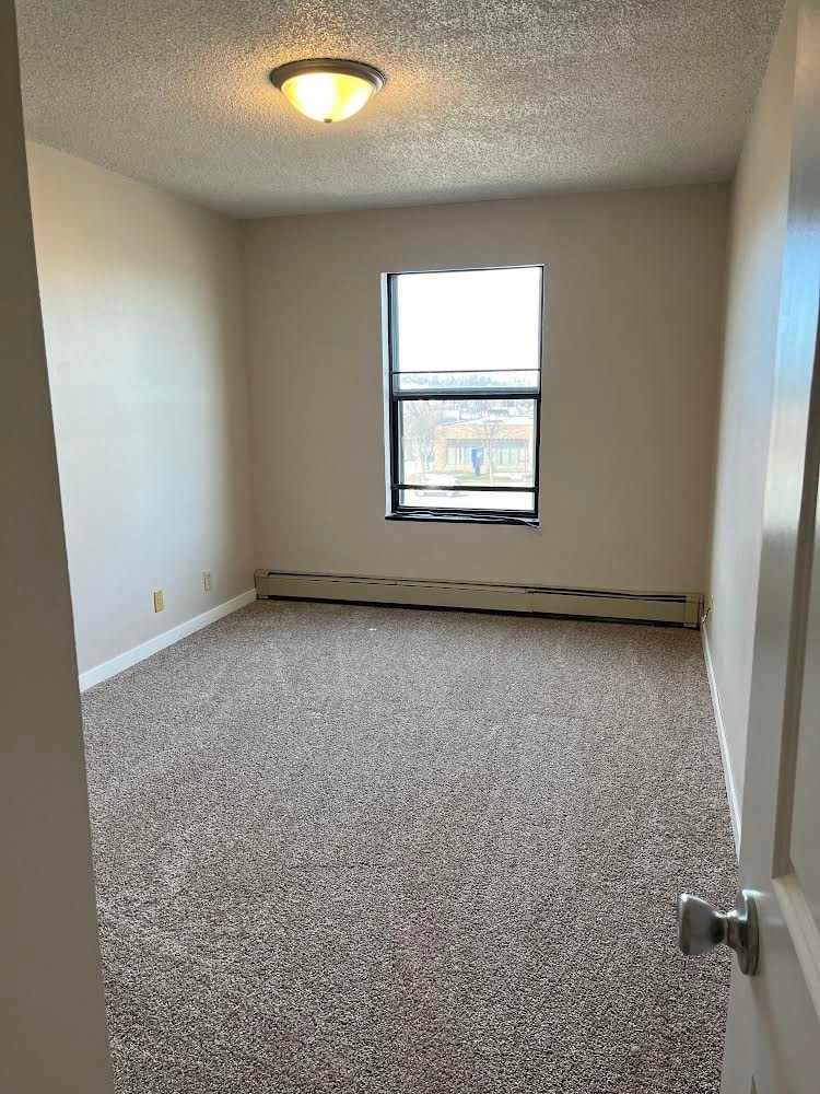 A room with a carpeted floor and a window.