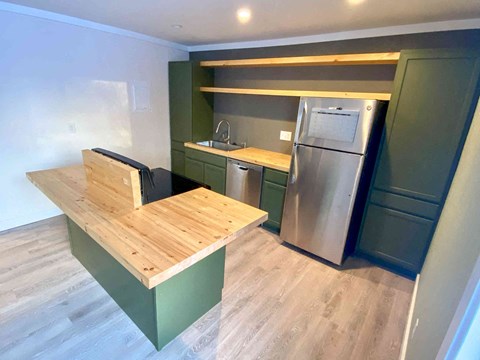 a kitchen with a wooden table and a stainless steel refrigerator