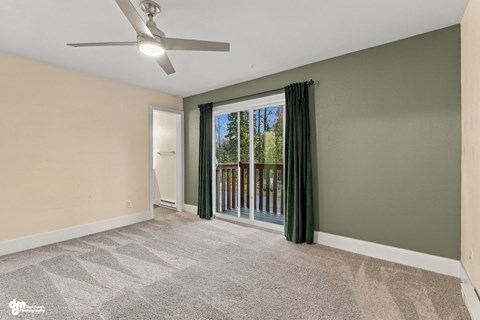 A room with a ceiling fan and a carpeted floor.