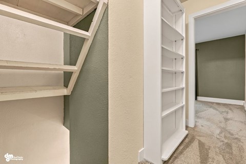 A white bookshelf is in a corner of a room.