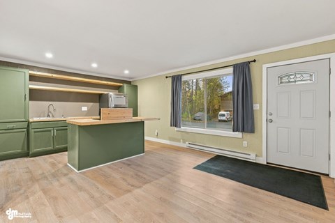 A kitchen with green cabinets and a wooden island.