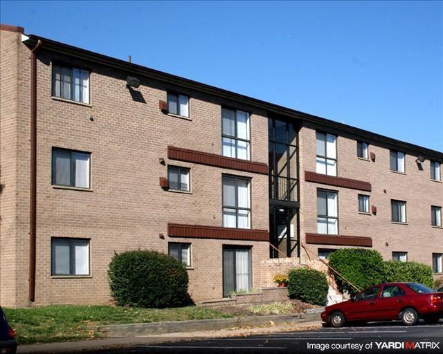 a red car parked in front of a brick building