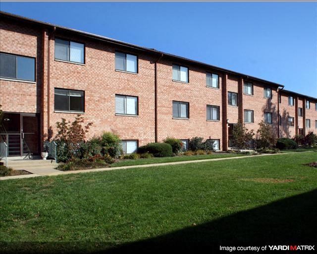 a brick building with green grass in front of it