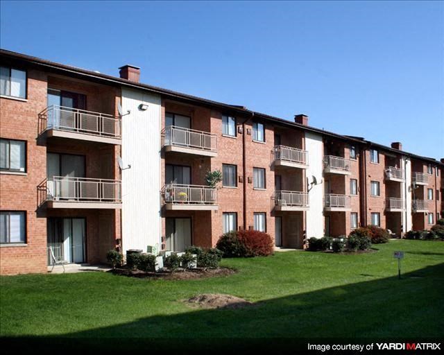 an apartment building with balconies and a green lawn