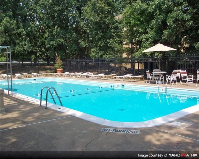 a swimming pool with tables and chairs around it