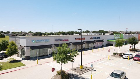 an aerial view of a shopping center with cars parked in a parking lot