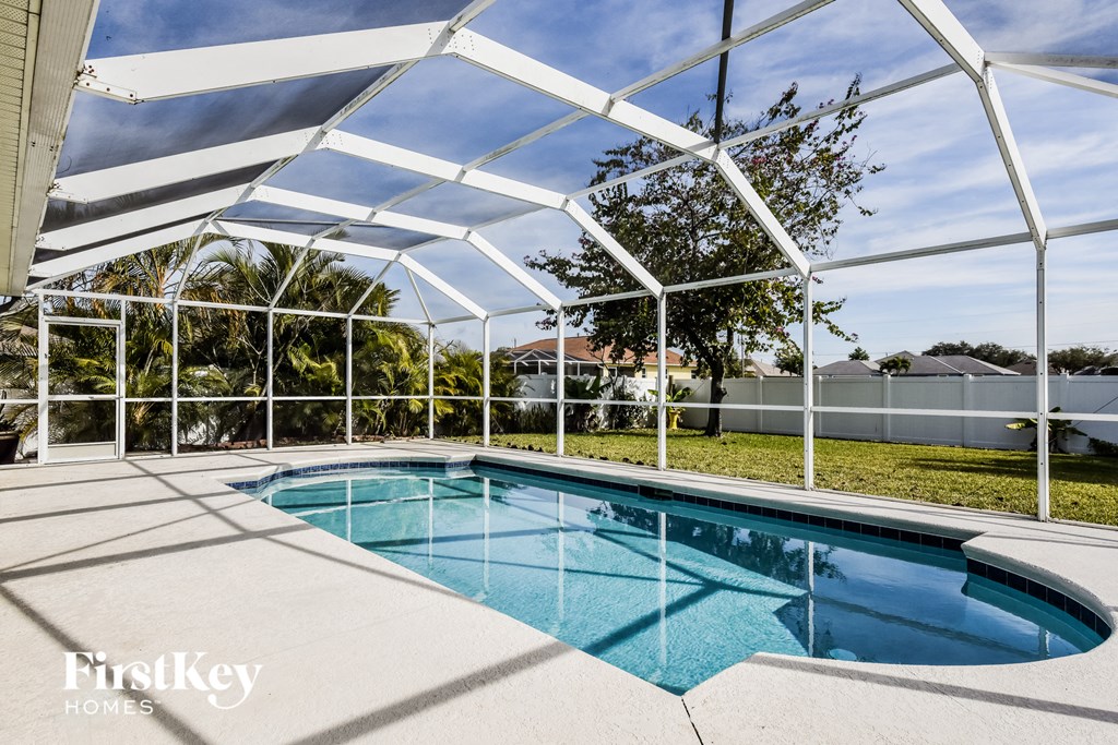 a pool is under a white roof next to a pool