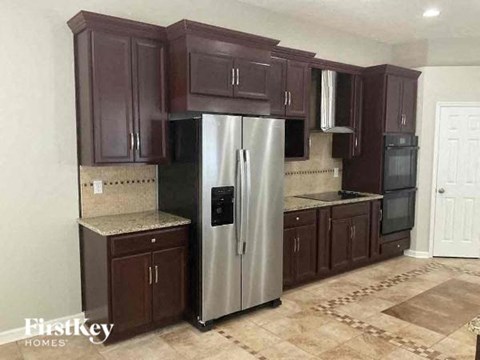 a kitchen with a stainless steel refrigerator and cabinets