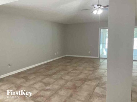 an empty living room with a ceiling fan