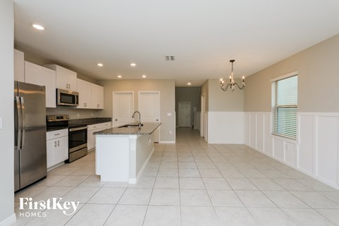 a large kitchen with white cabinets and stainless steel appliances