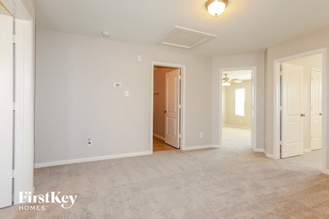 a spacious living room and dining room with white carpet and white doors
