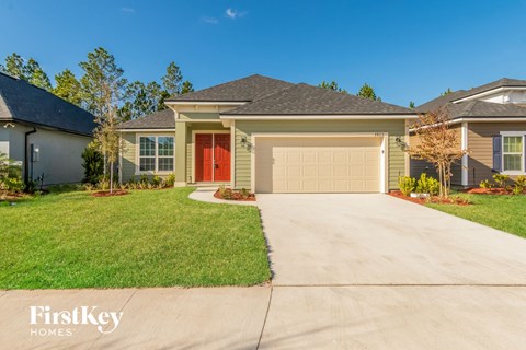 a beige house with a driveway and a garage door