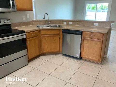 A kitchen with wooden cabinets and a tiled floor.