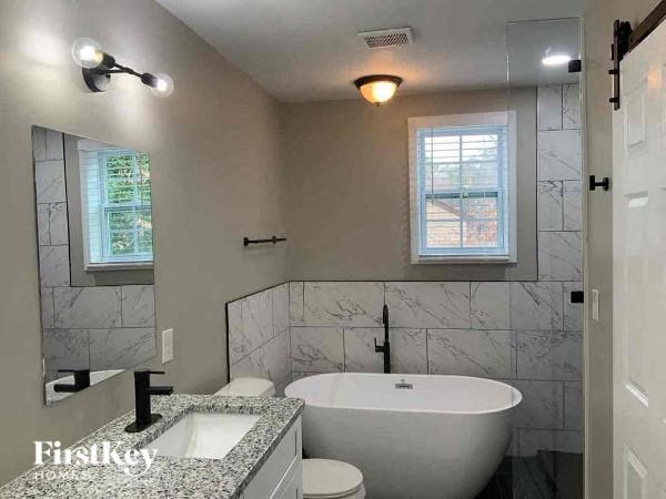 a bathroom with a tub and a sink and a toilet