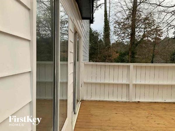 a balcony with a wood floor and a glass door