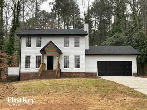 a white house with a black garage door
