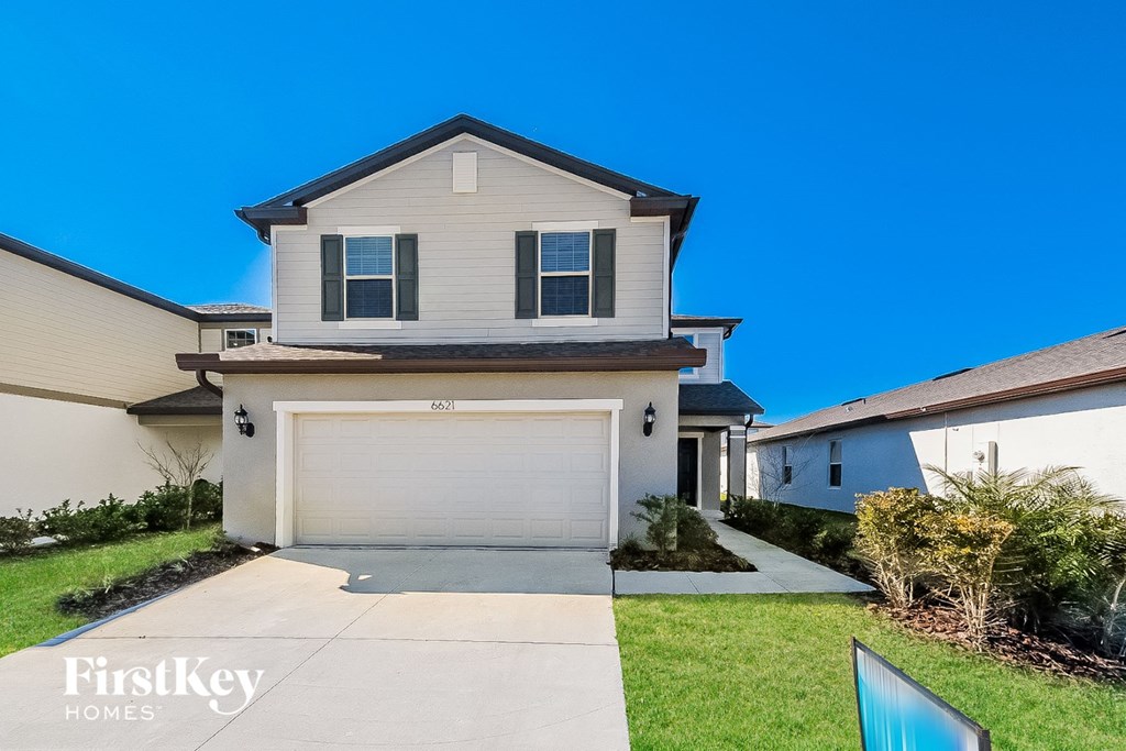 A two-story house with a garage is for sale.
