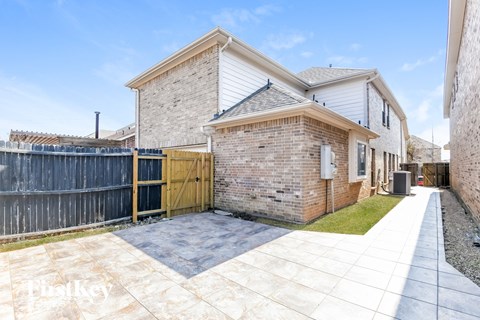 A house with a brick exterior and a wooden fence.