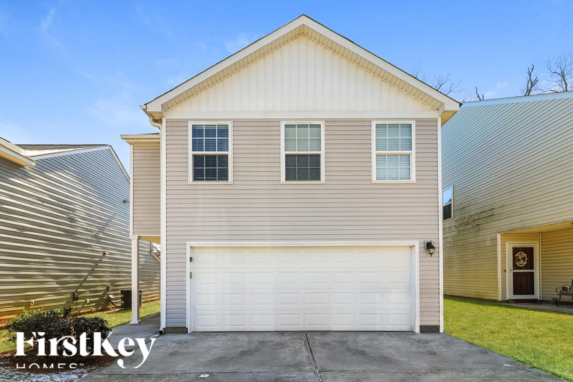 A house with a garage door and a sign that says "FirstKey Homes.".