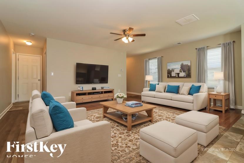A well-lit living room with a white sofa and a wooden coffee table.