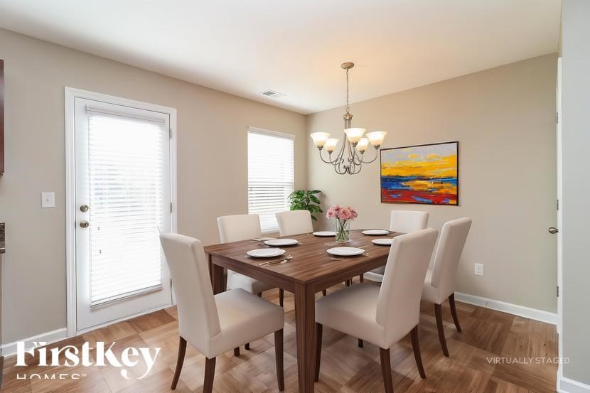 A dining room with a wooden table and chairs.