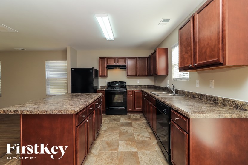 A kitchen with brown cabinets and a granite countertop.
