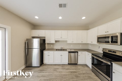 A kitchen with white cabinets and stainless steel appliances.
