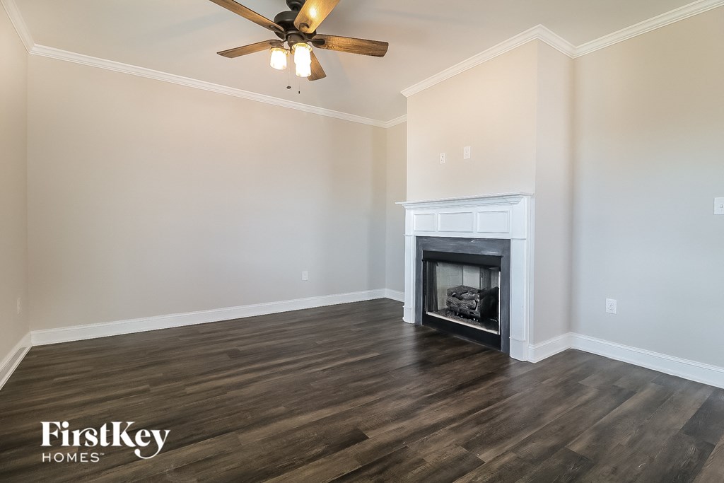 A room with a fireplace and a ceiling fan.