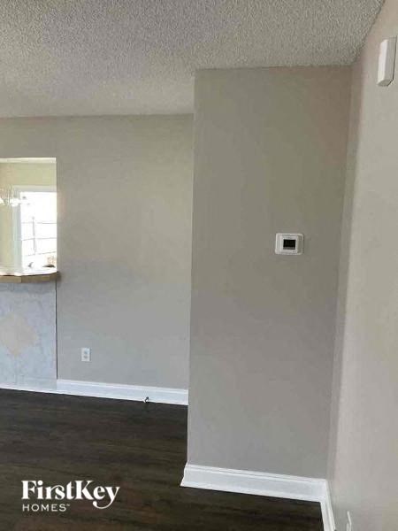 an empty living room with a heater on the wall
