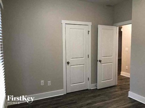 a living room with two white doors and a hallway